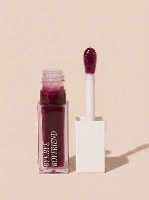 Deep cherry lip gloss stain for 90s editorial makeup look.